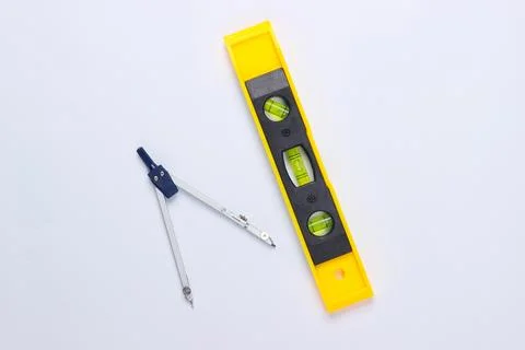 Construction level and compass on white studio background. Top view. Minimali Stock Photos