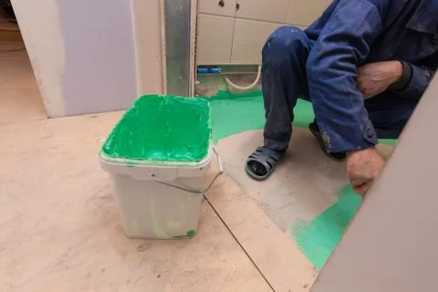 Construction level on the foreground and worker is working with palette-knife Stock Photos