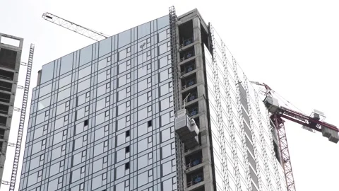 Construction lift moving up on building under construction Stock Footage 277657228