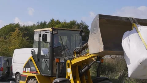 Construction Loader Carrying Large Bulk Material Bag Across Site Stock Footage 332975718