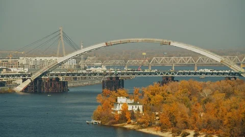 Construction of the long bridge across river in city Stock Footage 121993270