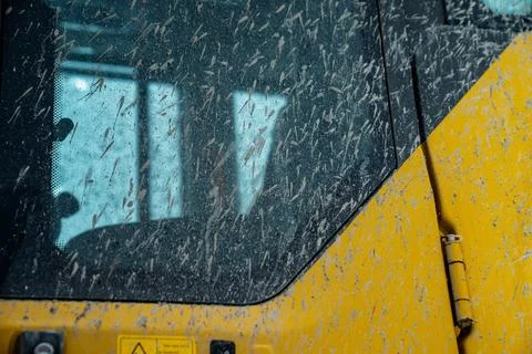 Construction machine cabin window covered in mud splashes and dust Stock Photos