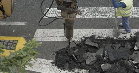 Construction Machine jackhammer breaking asphalt of the road Видео 141763971