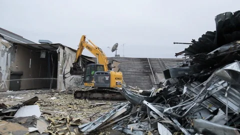Construction machine moves debris and metal scraps inside destroyed building Stock Footage 125055443