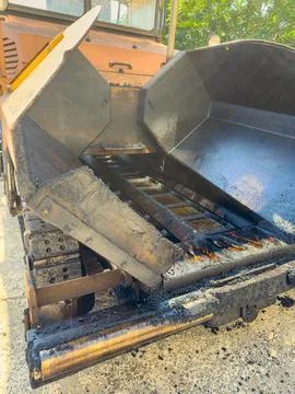 Construction machine is unloading material at a worksite in the daytime Stock Photos