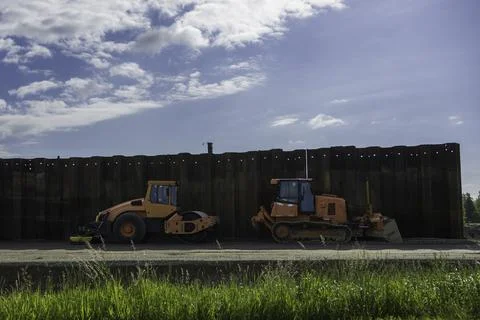 Construction machinery in front of a sheet pile wall Stock Photos
