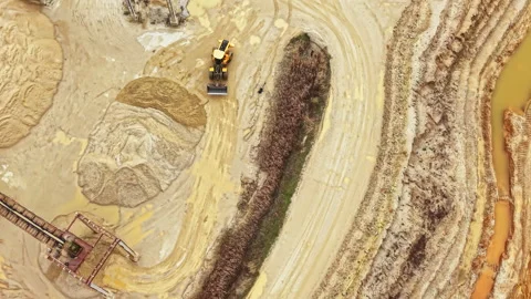 Construction machinery moves sand and dirt at a mining site during daytime Stock Footage 331901446