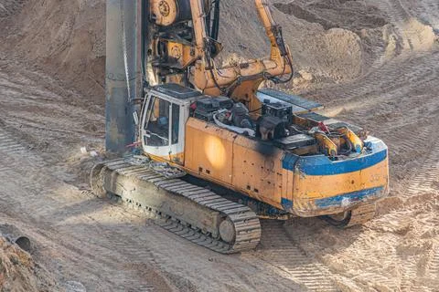 Construction Machinery at Work - Tracked Excavator Lifting Heavy Load Stock Photos