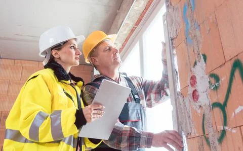 Construction male worker and engineer checking window panel Stock Photos