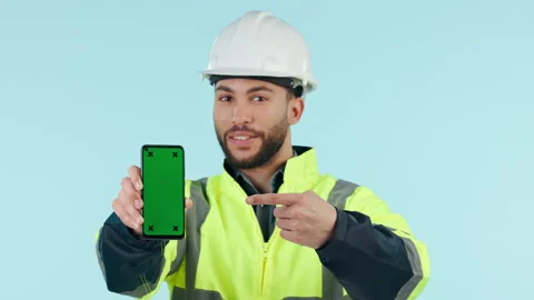 Construction man, green screen and point phone in studio, app promo and face by Stock Footage 250201561
