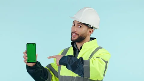 Construction man, green screen phone and studio with pointing, app promo or face Stock Footage 250199771