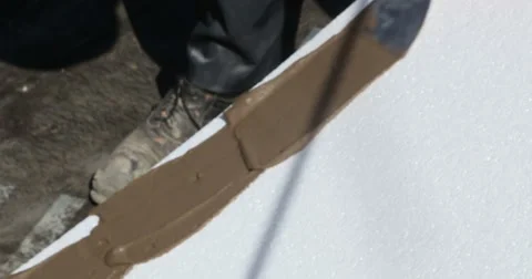 Construction. Man inflicts mortar on styrofoam. Stockbeeldmateriaal 53857430