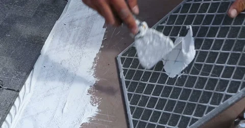 Construction. Man inflicts tile adhesive. Close up. Stockbeeldmateriaal 53857668