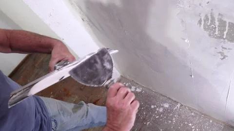 Construction Man Smoothing Plaster on Interior Drywall with Trowel Stock Footage 323872204