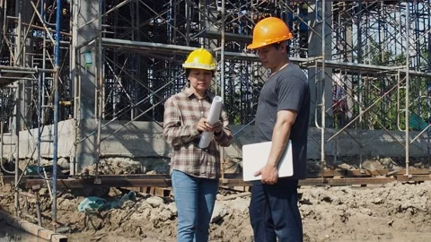 Construction manager and engineer checking plans on construction site. Stock Footage 137862224