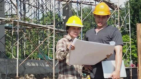 Construction manager and engineer checking plans on construction site. Stock Footage 142345753