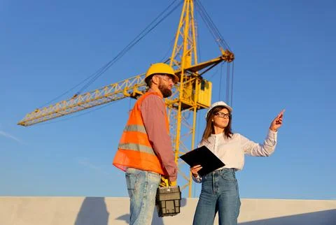 Construction manager and engineer discussing building project on site with .. Stock-Fotos