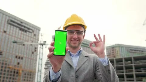 Construction manager is approving smartphone application during on-site audit Stock Photos