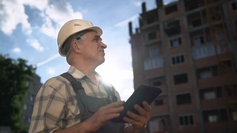 Construction manager controlling building site with pc tablet at sunset Stock Footage 91878209
