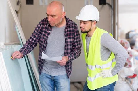Construction manager discussing work with builder Stock Photos