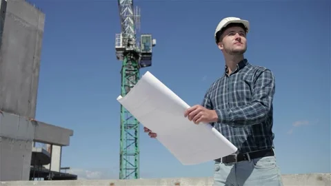 Construction manager examines building plans with confidence Stock Footage 311545626