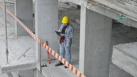 Construction manager inspecting concrete building progress with tablet Stock-Footage 348643320