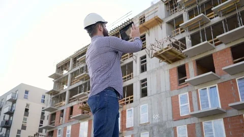 Construction manager make photo of construction by tablet. Slider shot left. 動画素材 70804552
