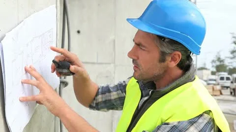 Construction manager reading plan and using walkie-talkie Stock Footage 18194747