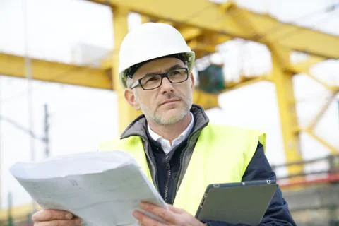 Construction manager on site reading blueprint Stock Photos