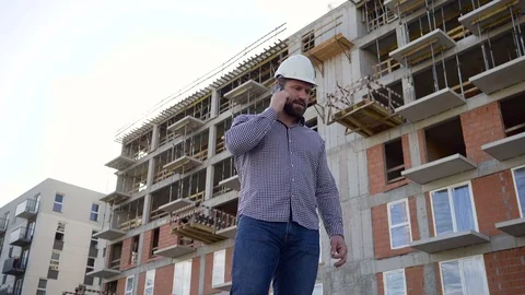 Construction manager talking by smartphone at building place. Vidéo 70804600
