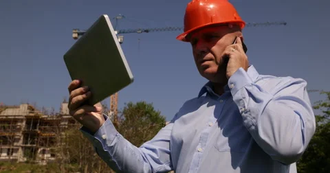 Construction Manager Using Tablet Check Plans Phone Orders Building Apartments Stock-Footage 50035878