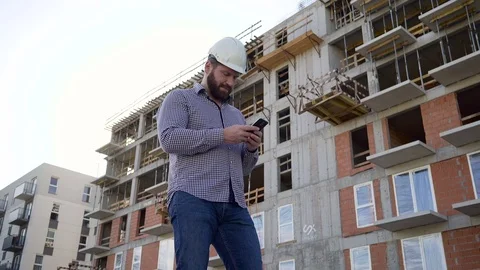 Construction manager writing message on smartphone at building place. Vídeo Stock 70804694