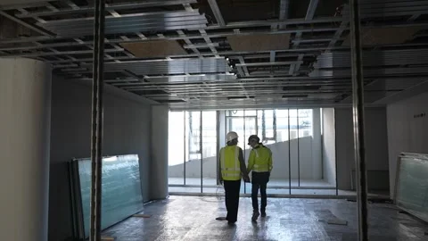 Construction managers inspecting ceiling structure in unfinished building Stock Footage 332834849