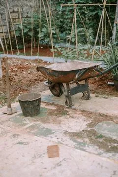 A construction material stroller stored in a garden area Stock Photos