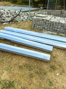 Construction materials are arranged on a worksite with piles of stone block.. Stock Photos