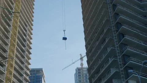 Construction materials lifting up by building crane to the top 動画素材 226136429