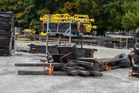 Construction materials stacked in a storage area amid trees during autumn Stock Photos