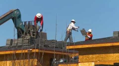 Construction, men hand-bombing tiles on roof of housing Stock Footage