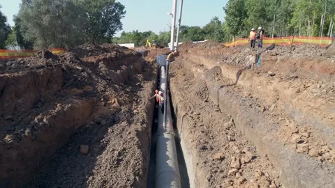 Construction men at work on site. Big white crane pouring cement on pipeline Stock Footage 131013736