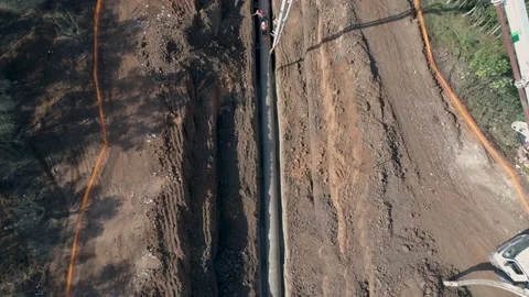 Construction men at work on site. Big white crane pouring cement on pipeline Stock Footage 131015535