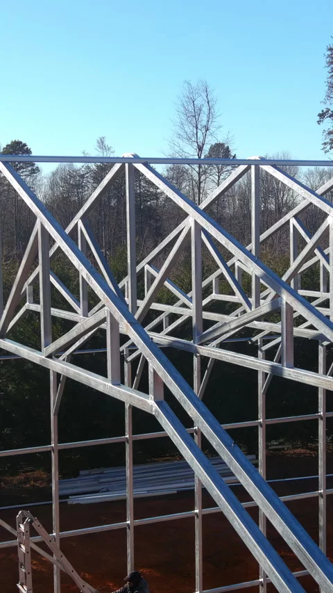 Construction of a metal framework for a large industrial building on a clear Stock Footage 306857787