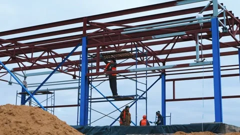 Construction of metal supports. Builders working on site Stock Footage 321003732