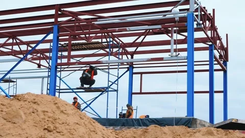 Construction of metal supports. Builders working on site Stock Footage 321003771