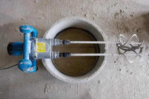 The construction mixer lies on a container with a solution Stock Photos