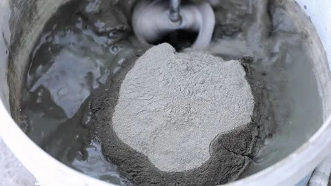 Construction mixer stirs putty in a bucket Stock Footage 220634550