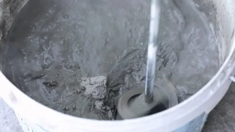 Construction mixer stirs putty in a bucket Stock Footage 229432837