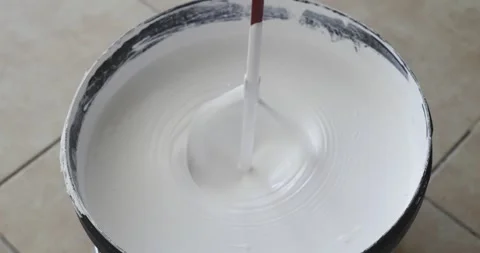 Construction mixer stirs thick white paint in bucket. Top view close-up Stock Footage 291830688
