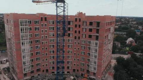 Construction of a multi-storey brick residential building of red color next to Stock Footage 126002213