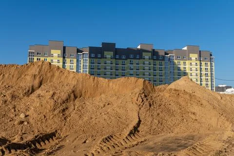 Construction of a multi-storey building with a crane against the blue sky. Stock Photos