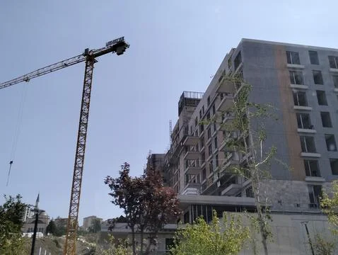 Construction of a multi-storey building with a crane on a background of blue sky Stock-Fotos